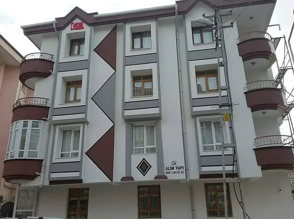 Keçiören'de beyaz-gri cephe, bordo baklava ve üçgen motifler, yuvarlak balkonlar